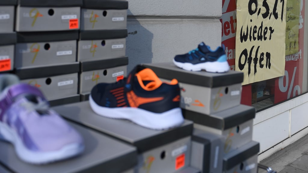 Sportschuhe stehen im Schaufenster eines schuhgeschäfts.