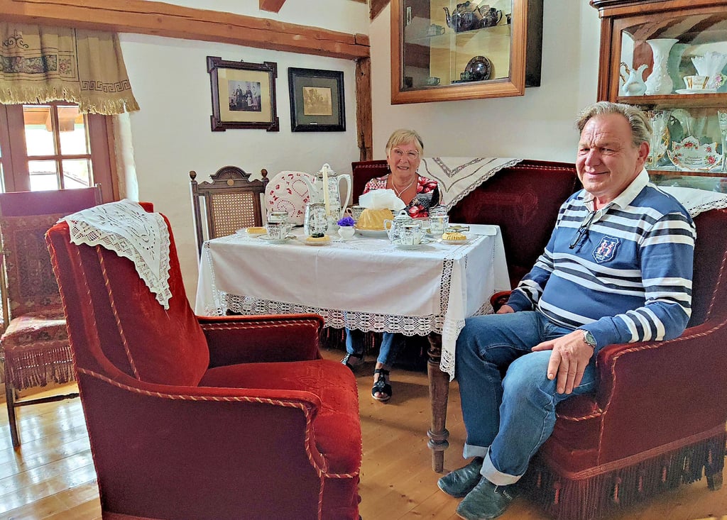 Girlinde Gelfert und Michael Wölfer vom Heimatmuseum in Ditfurt sitzen in der „guten Stube“ am feierlich gedeckten Kaffeetisch.