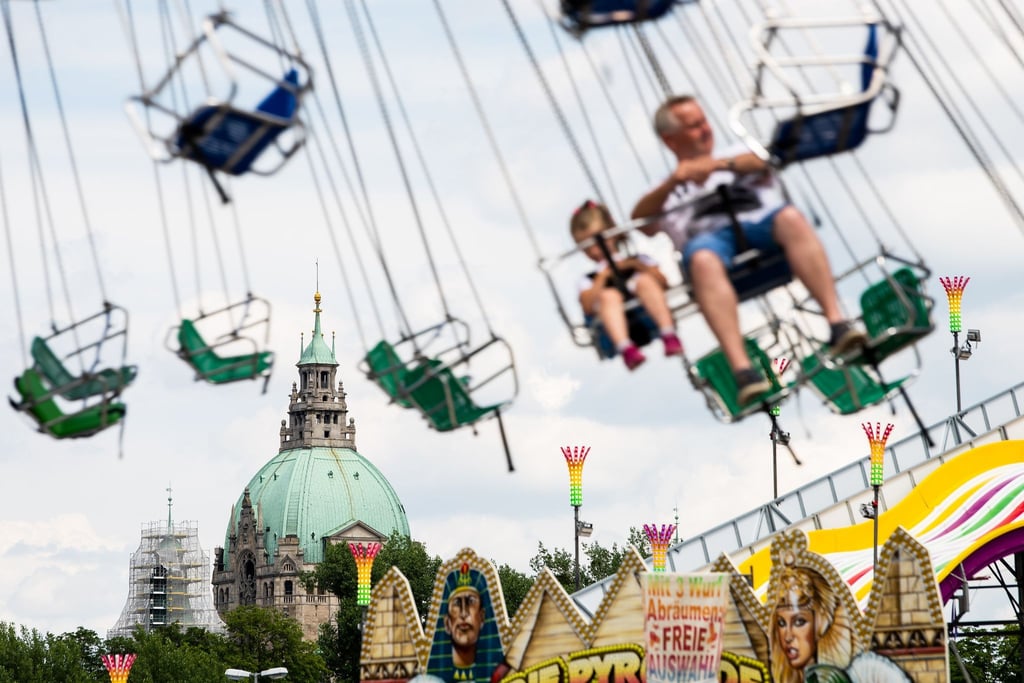 Das Neue Rathaus ist beim Pop-Up Freizeitpark "Hanno Park" auf dem Schützenplatz hinter einem Karussell zu sehen.