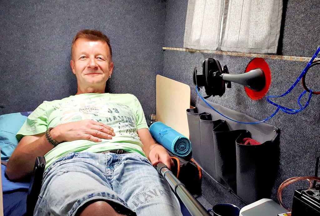 Klein – aber mein: Marco Düsterhöft in seinem Fahrradanhänger, Marke Eigenbau. Alles an Bord: zusammenbaubarer Tisch und Stuhl, kleine „Küche“ mit Gaskocher und eigene Stromversorgung.