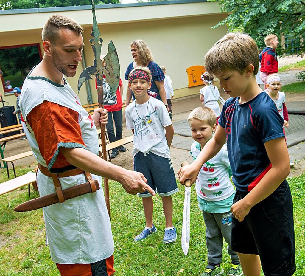 Kinder-Kirschfest in der Kindertagesstätte Am Holländer: Erzieher Thomas Speck lässt Magnus aus dem Hort das Schwert tragen