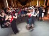 Absolventen und Absolventinnen eines Gymnasiums tanzen auf ihrem Abiball.