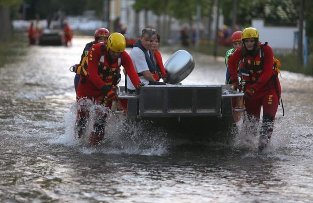 Wasserretter der DLRG bringen am 08.06.2013 über eine durch das Hochwasser der Elbe überflutete Straße im Ortsteil Rothensee in Magdeburg (Sachsen-Anhalt) Anwohner aus ihren Häusern. Die Stadt Magdeburg hat die Bürger des Stadtteils aufgefordert, ihre Häuser zu verlassen. Foto: Jens Büttner/dpa +++(c) dpa - Bildfunk+++