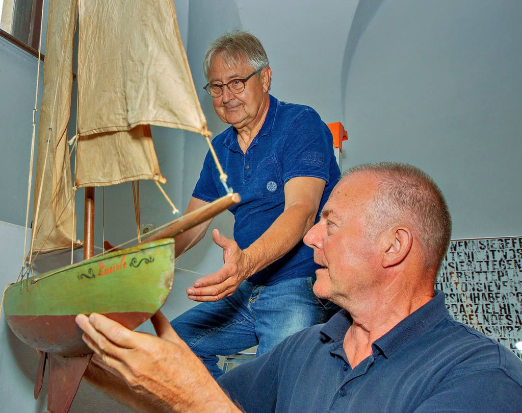 Wolfgang Schröder (vorne) und Claude Bernard heben ein französisches Spielschiff auf seinen Platz in der Fensternische des Museums Schloss Moritzburg.
