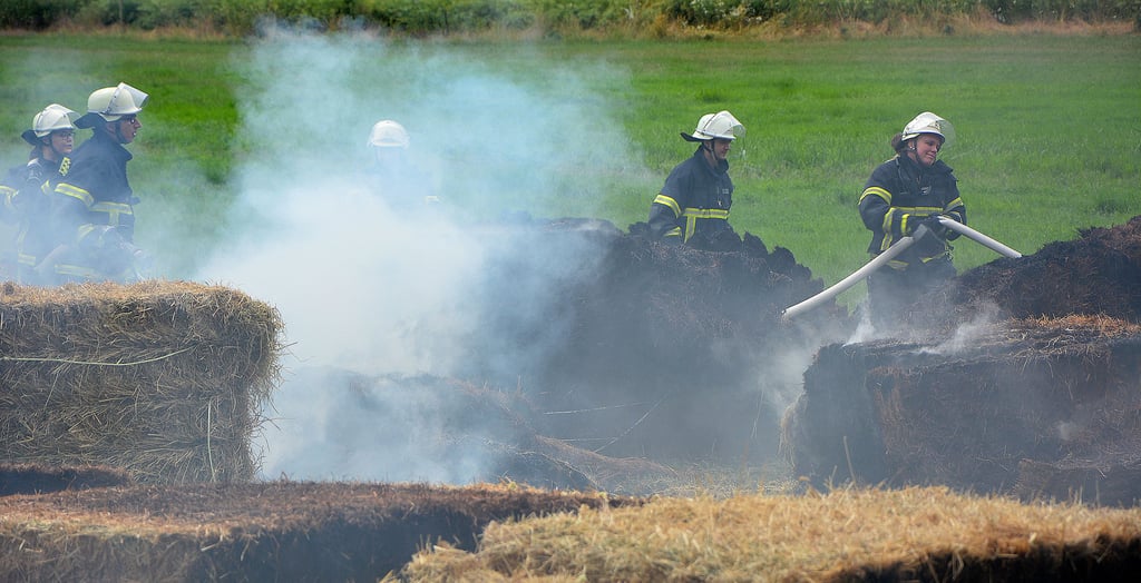 Landwirte des Gutshofes Dobbrun brachten die Heuballen aus der offenen Scheune nach draußen, die Feuerwehr löschte sie dort.