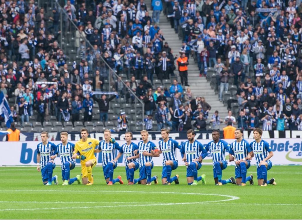 Die Spieler von Hertha (v.l.) Peter Pekarik, Mitchell Weiser, Torwart Rune Jarstein, Ondrej Duda, Vladimir Darida, Per Skjelbred, Niklas Stark, Marvin Plattenhardt, Salomon Kalou, Karim Rekik und Genki Haraguchi knien vor dem Anpfiff zusammen auf dem Spielfeld.