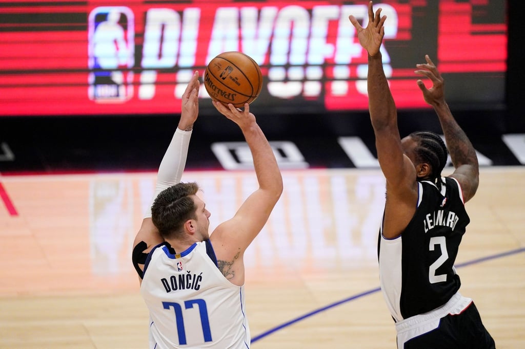 Luka Doncic (l) von den Dallas Mavericks wirft über Clippers-Starspieler Kawhi Leonard.
