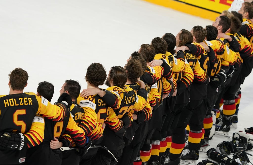 Das deutsche Eishockey-Nationalteam steht Arm in Arm auf dem Eis.
