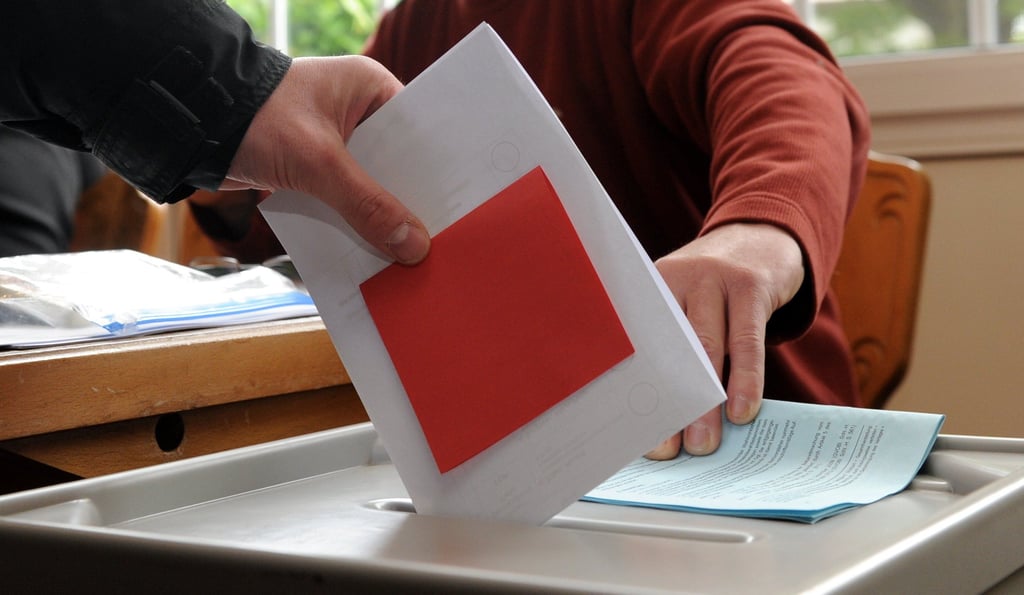 Ein Wähler wirft seine Stimmzettel in eine Wahlurne.