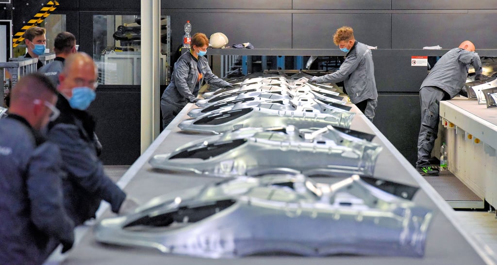 Hochwertig die Bauteile, hochwertig die Arbeitsplätze. Im Smart Press Shop ist Präzision gefragt. Hier laufen Bauteile für den Macan vom Band.