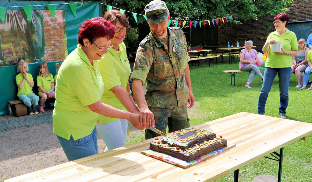 Die Geburtstagstorte aus Anlass des zehnjährigen Bestehens der Evangelischen Grundschule Holzdorf wird angeschnitten. Das übernehmen Schulleiterin Betty Riedel (Mitte), Petra Lehmann und der frühere Vorsitzende des Schulfördervereins, Michael Witte.