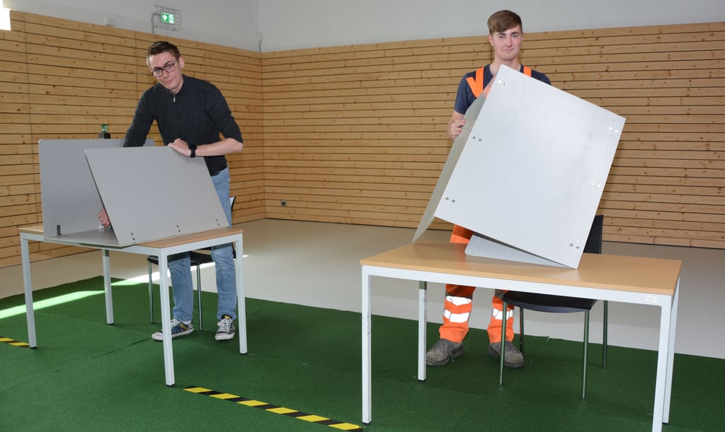 Der Gymnastikraum der Diesterweg-Sekundarschule in Burg dient am Sonntag als Wahllokal. René Teßmann (links) und Bendix Rathmann stellen hier die mobilen Wahlkabinen auf. Zuvor wurde der Fußboden zum Schutz des Parketts mit Auslegware verlegt.