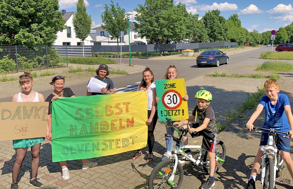 Mitglieder der Initiative „Selbst Handeln Olvenstedt" und Anwohner freuen sich, dass ihr Anliegen zur Temporeduzierung im Rennebogen in Magdeburg bei der Stadtverwaltung Gehör fand.
