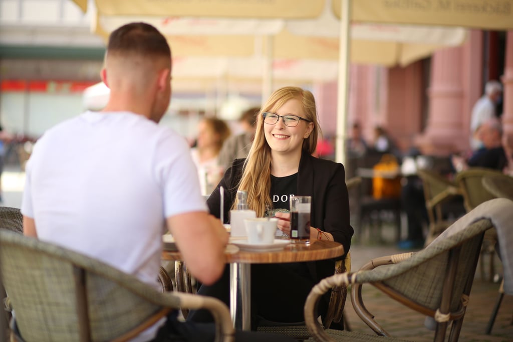 Gäste sitzen in einem Straßencafé in Quedlinburg.