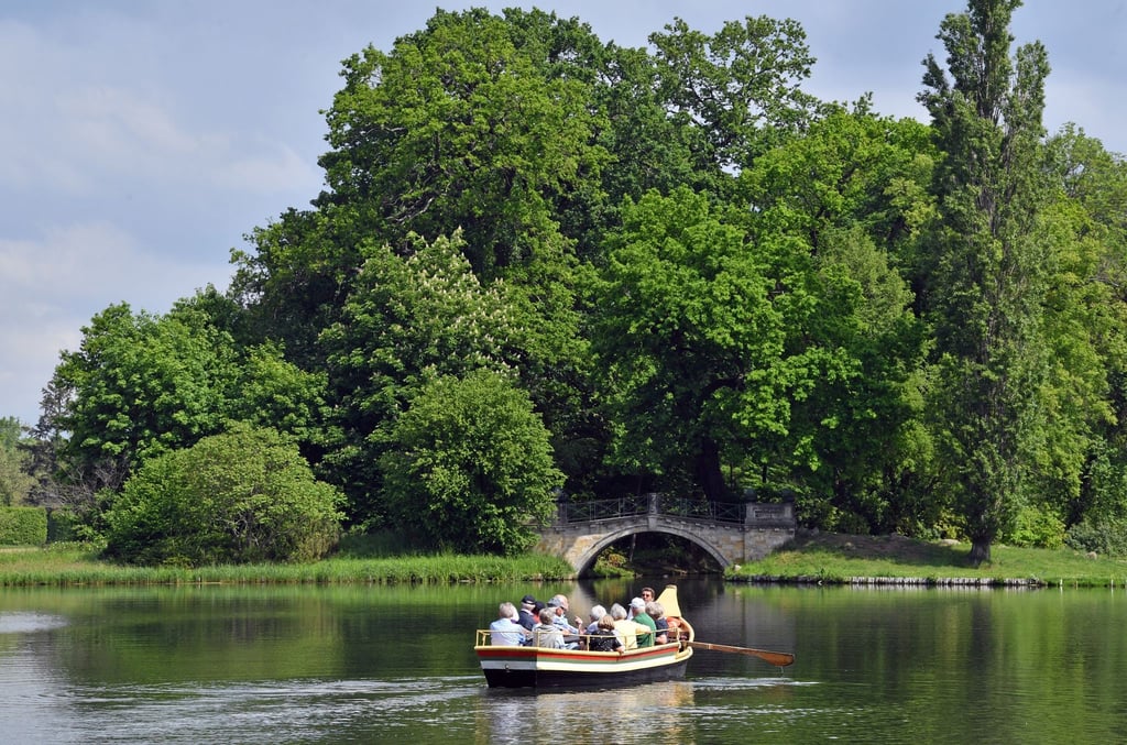 Eine Gondel mit Touristen fährt im Wörlitzer Park über den See.