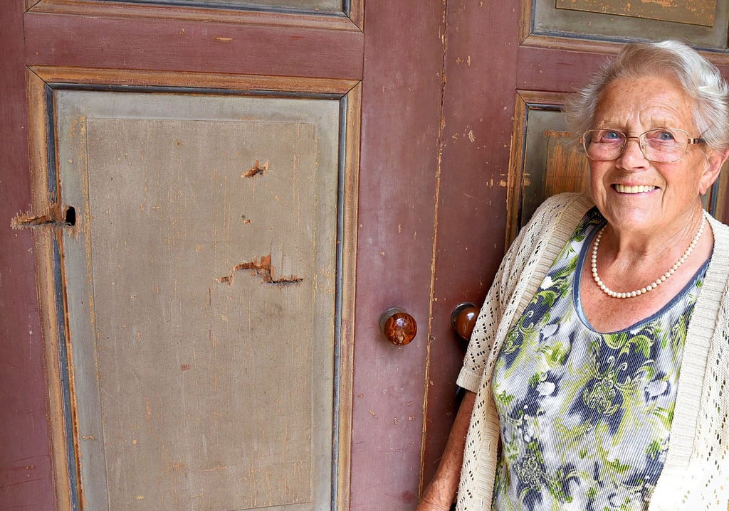 Ruth Christ (88) an der Tür mit den Einschüssen. Die Rosenburgergerin kann sich noch gut an die Ereignisse vom April 1945 erinnern, als es im Dorf lebensgefährlich war, das Haus zu verlassen.