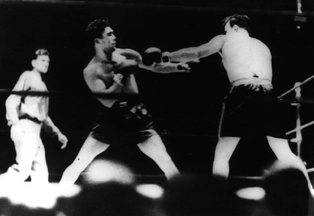 Das Archivbild vom 12.06.1930 zeigt den deutschen Boxer Max Schmeling (M), der zum Schwergewichts-Weltmeister gekürt wurde, nachdem der Amerikaner Jack Sharkey (r) beim Kampf im Yankee-Stadium in New York disqualifiziert worden war. Sharkey hatte Schmeling mit einem linken Haken unter die Gürtellinie auf die unfeine Art auf die Bretter geschickt. Deutschlands Sport-Idol Max Schmeling ist im Alter von 99 Jahren gestorben. Wie die Max-Schmeling-Stiftung in Hamburg am Freitag (04.02.2005) mitteilte, ist der Tod bereits am Mittwoch eingetreten. Der Weltmeister im Schwergewichtsboxen wurde bereits am Freitag in seinem niedersächsischen Wohnort Hollenstedt beerdigt. Eine Trauerfeier in Hamburg befindet sich in Vorbereitung. (Bestmögliche Qualität) +++(c) dpa - Bildfunk+++