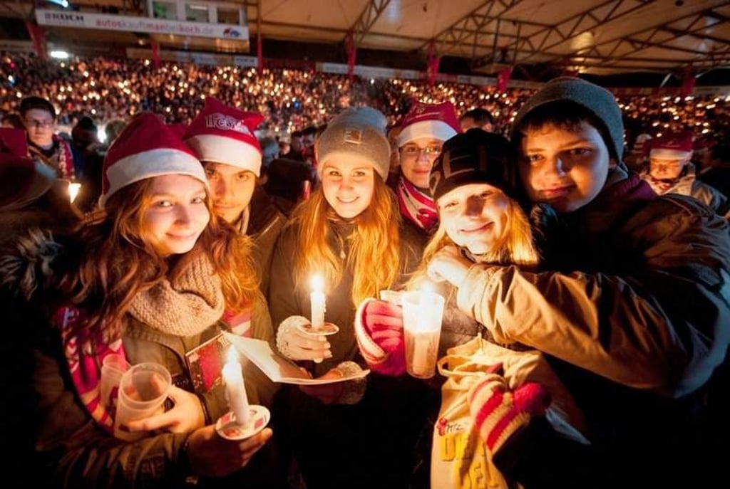 Junge Unionfans singen am 23.12.2014 im Kerzenschein Weihnachtslieder beim 1. FC Union Berlin im Stadion «An der Alten Försterei». Zum Weihnachtssingen kamen 27 500 Fans des Berliner Zweitligisten 1. FC Union in das Stadion des Berliner Traditionsclubs. Foto: Oliver Mehlis/dpa +++(c) dpa - Bildfunk+++
