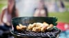 Würstchen liegen auf einem Grill. Die Stadt Magdeburg hat acht Plätze ausgewiesen, auf denen mit eigenem Gerät gegrillt werden darf.