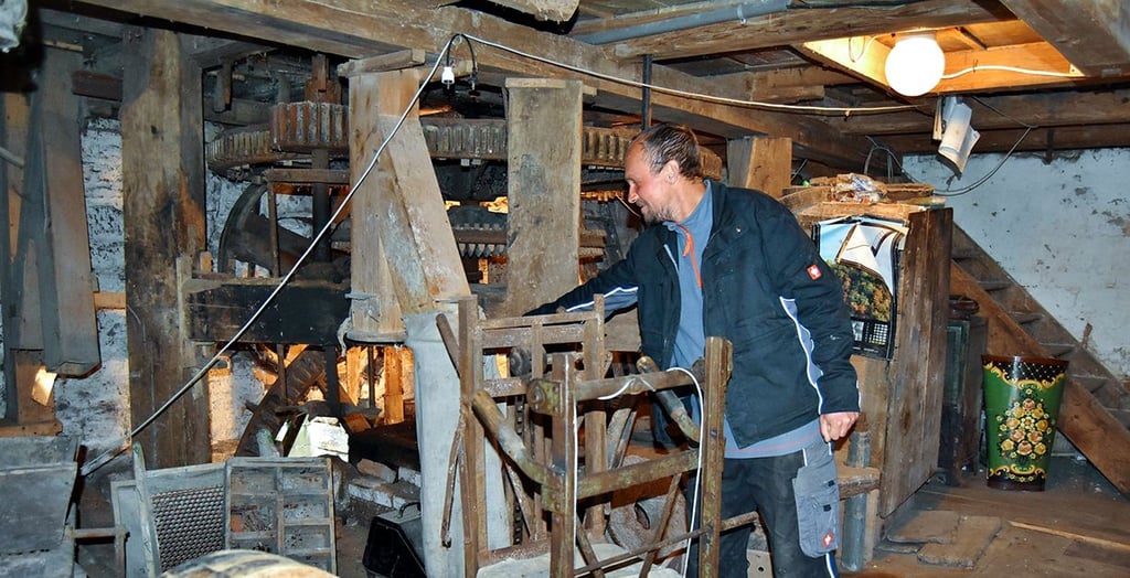 Stefan Ettrich freut sich, dass sich vorerst das Wasserrad der Nitsche-Mühle wieder dreht. Er zeigt, wo das Schrot abgefüllt wurde.