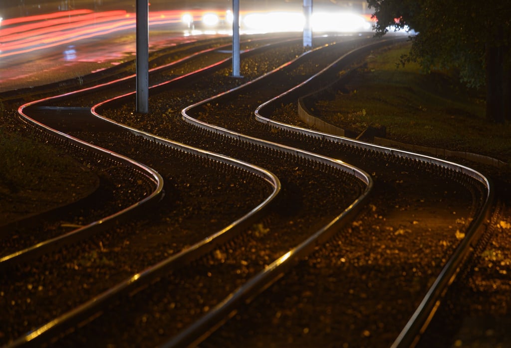 Leere Gleise werden von Straßenlaternen angeleuchtet.