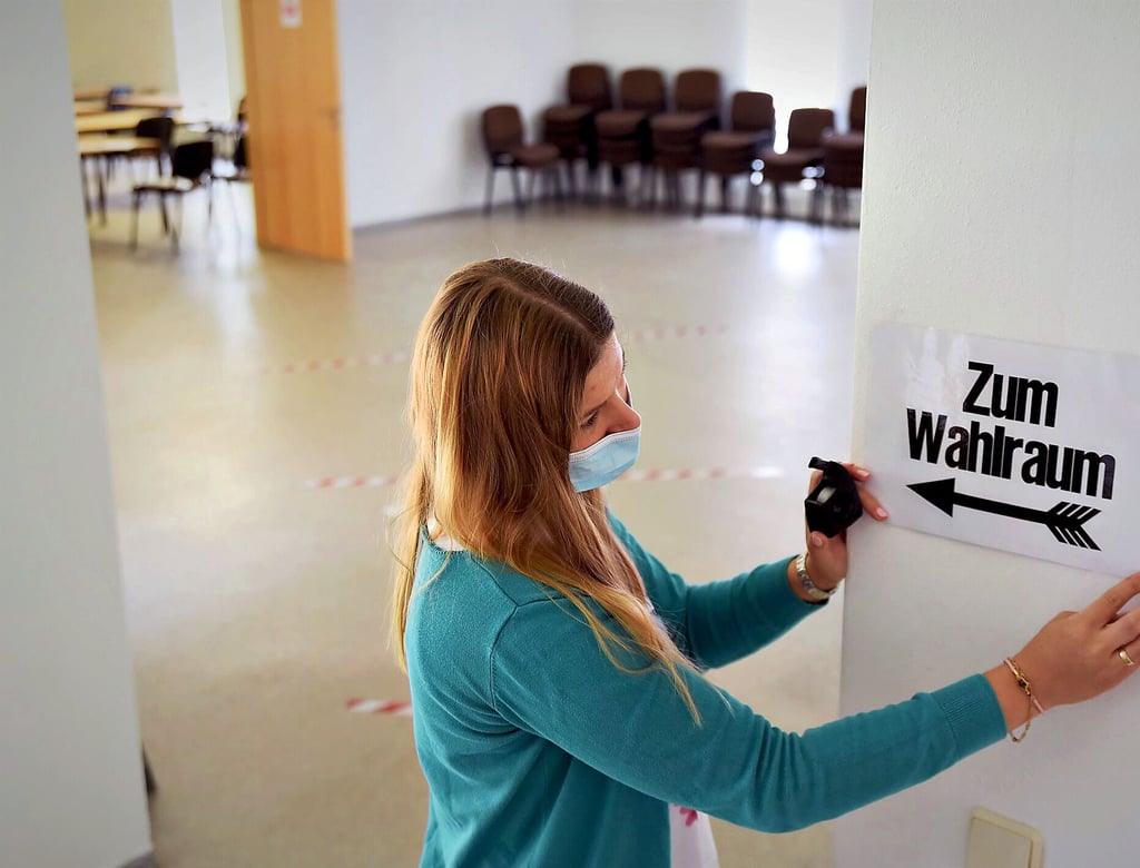 Nur mit Maske: In Wulfen bringt Wahlvorsteherin Luisa Trutschel Hinweisschilder an.