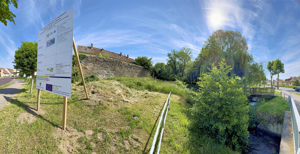 Ein Bauschild informiert über das anstehende Ehle-Sanierungsprojekt. Der über 180-Grad-Panoramaschwenk erlaubt es, dass die Bundesstraße rechts und links im Bild zu sehen ist.