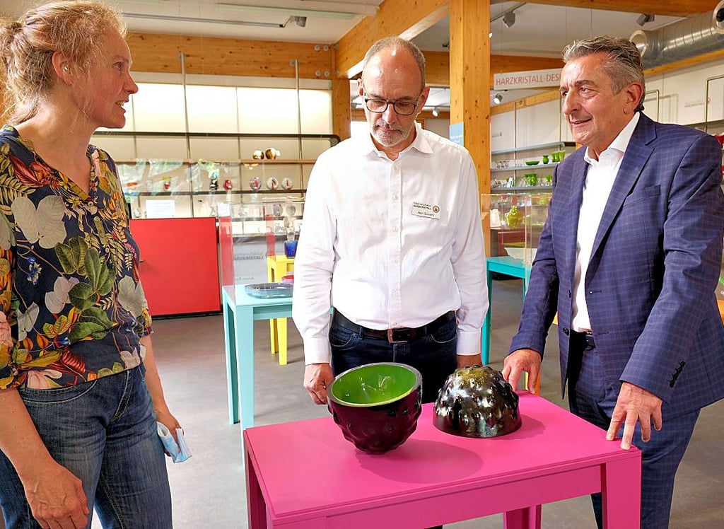 Die Hallenser Künstlerin Judith Runge erläutert Otto Sievers, Betriebsleiter der Glasmanufaktur, und Kulturstaatssekretär Gunnar Schellenberger (von links) ihren Wettbewerbsbeitrag: eine Schale auf fünf Füßen.