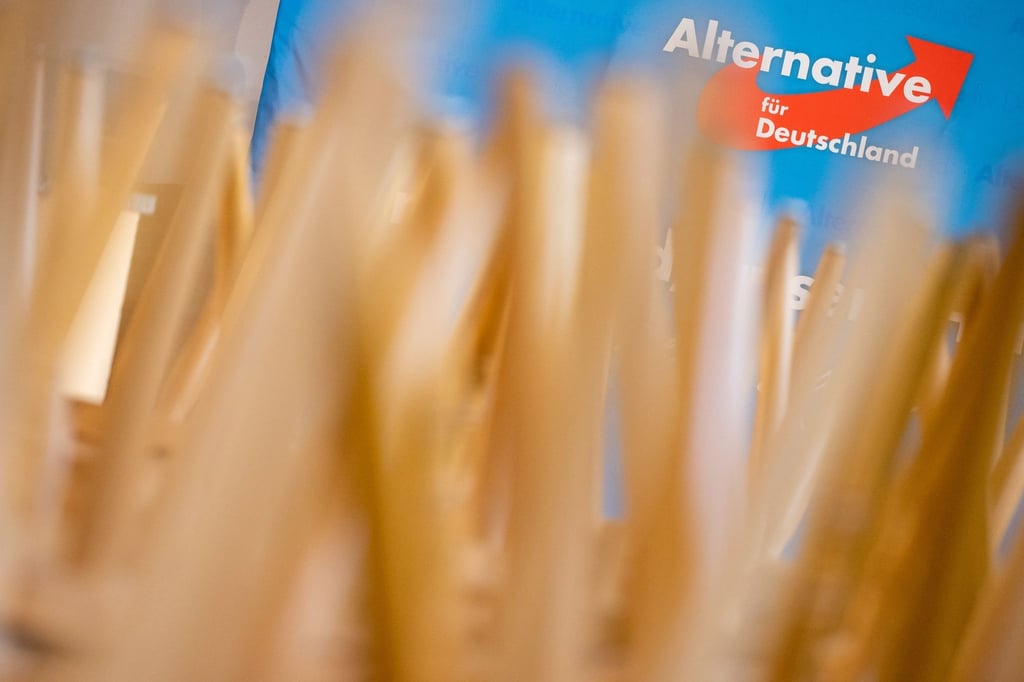 Stühle stehen umgedreht auf Tischen vor einem Aufsteller mit dem Logo der AfD.
