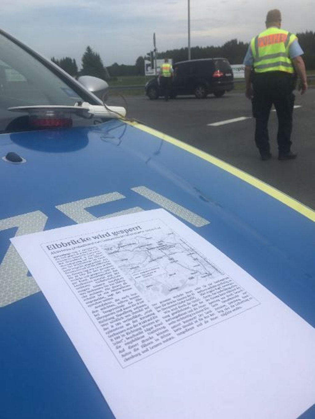 lizisten aus Möser reichen Ortsunkundigen einen Zettel mit einem Volksstimme-Beitrag plus Karten für die 60-km-Umleitung.