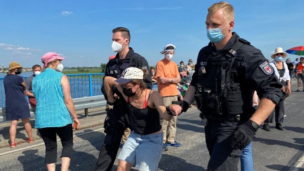 Demonstrantin wird vom Brückengeländer abgeführt..
