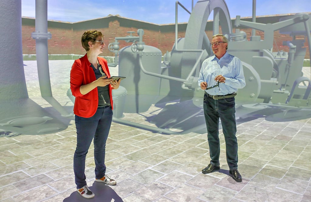 Dr.-Ing. Tina Haase vom Fraunhofer-Institut Magdeburg mit Reinhard Schenkewitz vom Kuratorium Industriekultur in der virtuellen Umgebung eines Exponats des Technikmuseums. So ähnlich können ab 2022 auch Besucher des Museums Maschinen mit Hilfe ihres Handys erleben.