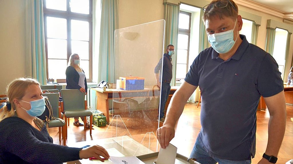 Stefan Job gibt im Rathaus in Haldensleben seine Stimme für die Landtagswahl ab. Wahlhelferin Lina Lüders gibt den Einwurf frei.
