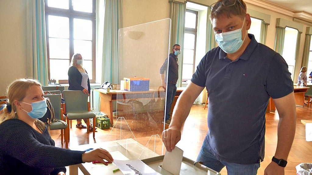 Stefan Job gibt im Rathaus in Haldensleben seine Stimme für die Landtagswahl ab. Wahlhelferin Lina Lüders gibt den Einwurf frei.