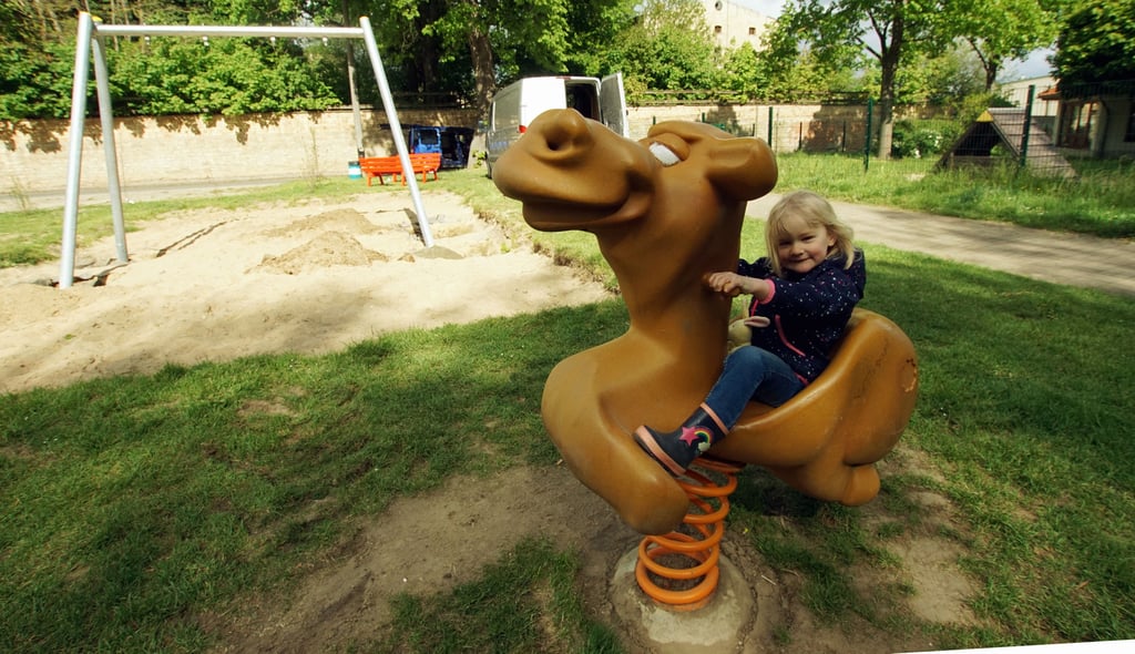 Begeistert schaukelt die dreijährige Nayla auf einem Federtier des neuen Spielplatzes in Cochstedt.