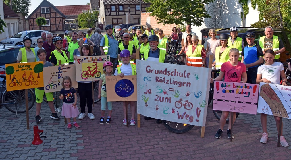 Kinder präsentieren vor dem Start der Fahrrad-Demo Plakate, die im Hort der Rätzlinger Grundschule entstanden sind. Die Tour führte auf der Landesstraße 24 über Kathendorf und Etingen nach Wegenstedt.