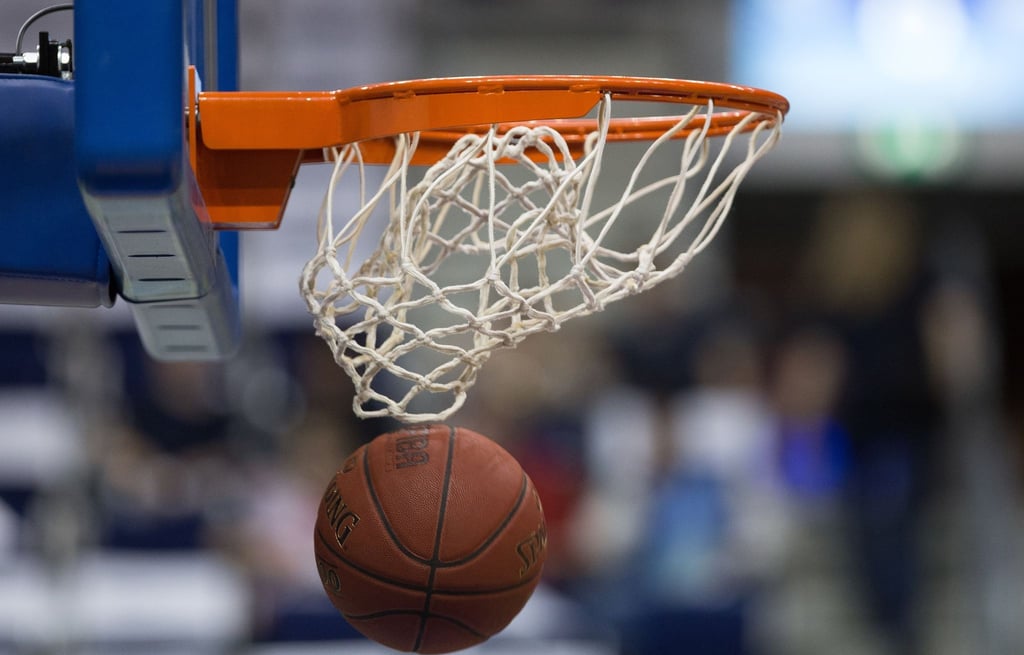 Ein Basketball fällt durch das Netz vom Basketballkorb.