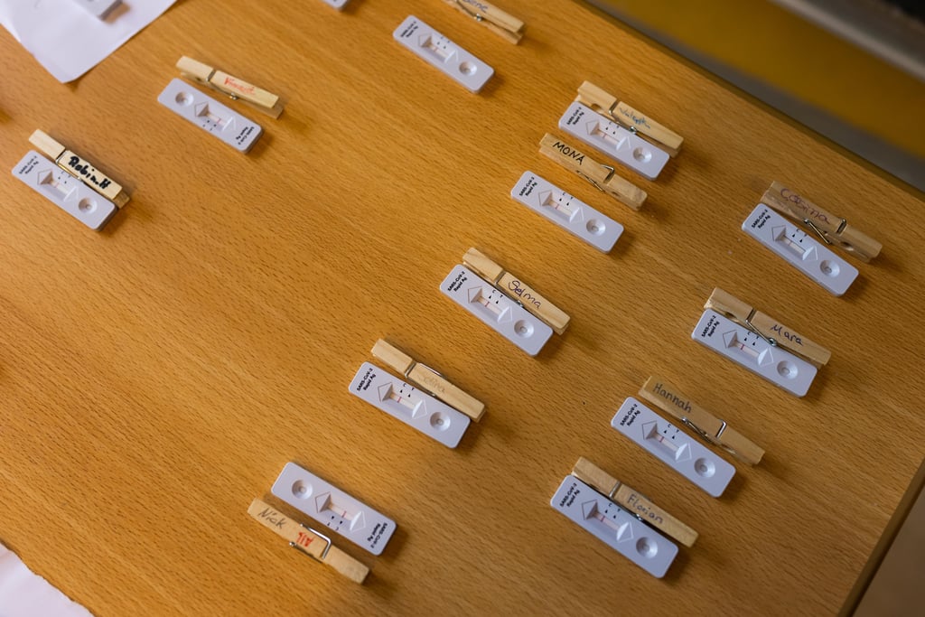 Corona-Schnelltests liegen in einer Schule auf einem Tisch zur Auswertung.