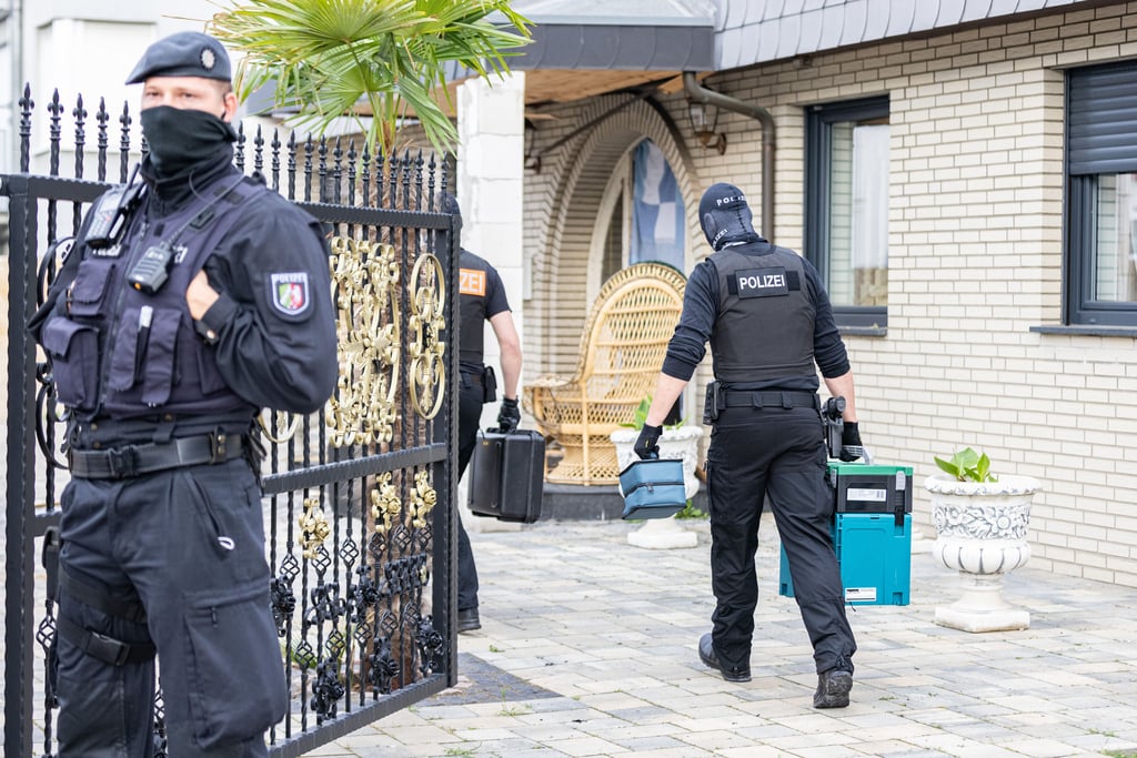 08.06.2021, Nordrhein-Westfalen, Leverkusen: Polizisten betreten eine Villa. Bei Ermittlungen gegen Clankriminalität durchsuchten Spezialkräfte der Polizei rund 30 Objekte in Nordrhein-Westfalen.