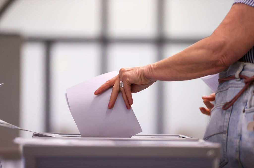 Eine Frau wirft ihren Stimmzettel in eine Urne in einem Wahllokal.