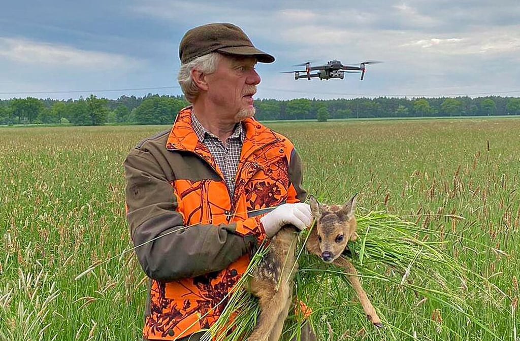 Hans-Günther Rose hält ein junges Kitz in den Händen, das bei dem Einsatz gerettet werden konnte. Die Wärmebildkamera der Drohne hatte es aufgespürt.