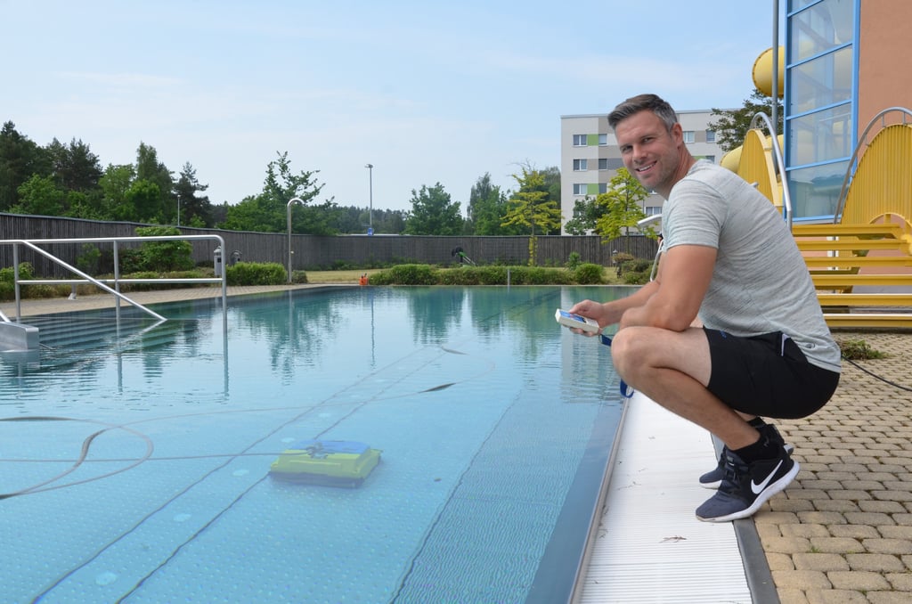Am 21. Juni 2021 wird das Rolli-Bad nach coronabedingter Zwangspause eröffnet. Schwimmeister Thomas Ritzmann bedient per Fernbedienung den kleinen Roboter, der unter Wasser aufräumt.