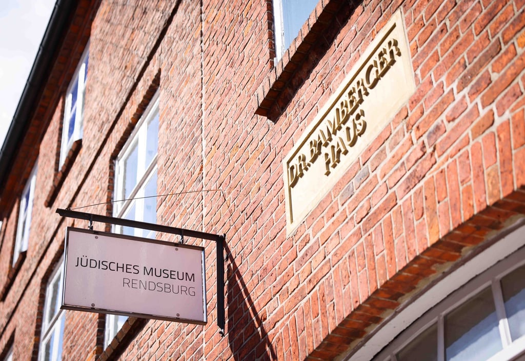 Ein Hinweisschild auf das Jüdische Museum Rendsburg hängt an der Fassade.