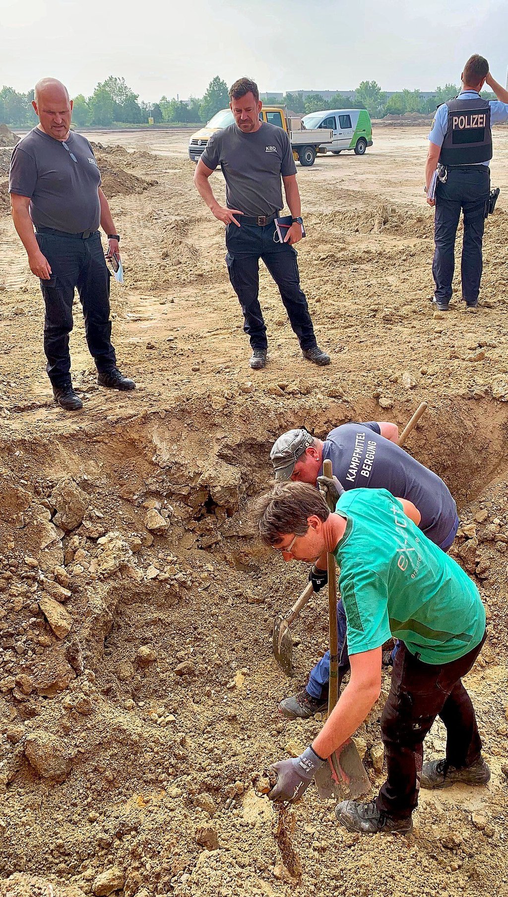 Mitarbeiter der Kampfmittelräumfirma Ex-act aus Zwickau legen auf der Baustelle am Dienstag die zur Sicherheit abgedeckte Bombe wieder frei.