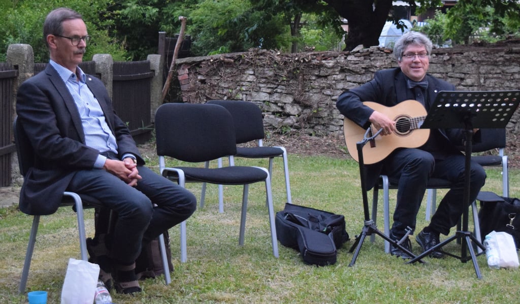 Propst Christoph Hackbeil (l.), der seinem Ruhestand entgegensieht, und Landesbischof Friedrich Kramer singen nach der kurzen Andacht in der St.-Lamberti-Kirche mit den Gästen im Kantoratsgarten.