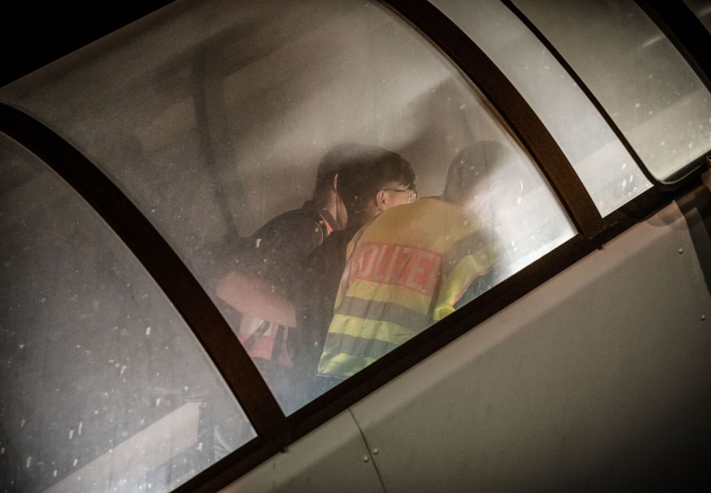 Polizeibeamte begleiten einen Afghanen in ein Charterflugzeug.