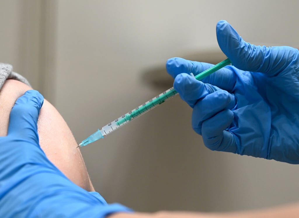 Ein Impfarzt setzt zur Immunisierung gegen Corona eine Spritze. Im Magdeburger Impfstreit unterlag jetzt ein Sachse vor Gericht.