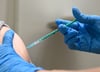 Ein Impfarzt setzt zur Immunisierung gegen Corona eine Spritze. Im Magdeburger Impfstreit unterlag jetzt ein Sachse vor Gericht.