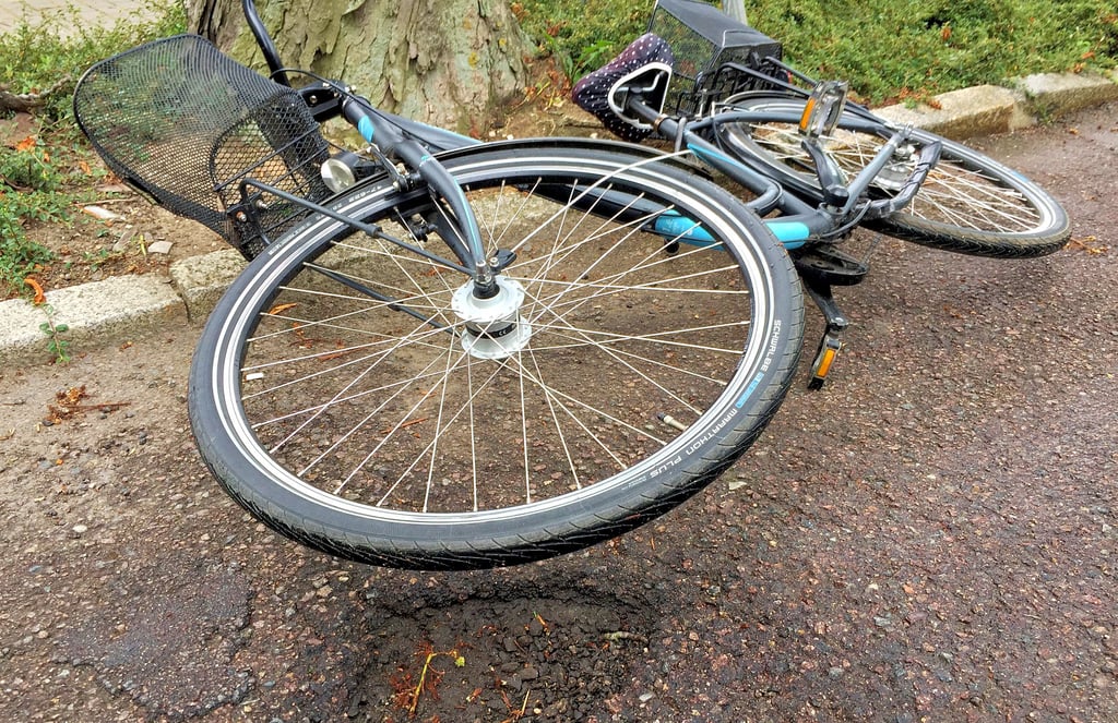 Ein Straßenschaden verursachte den Unfall einer Radfahrerin.