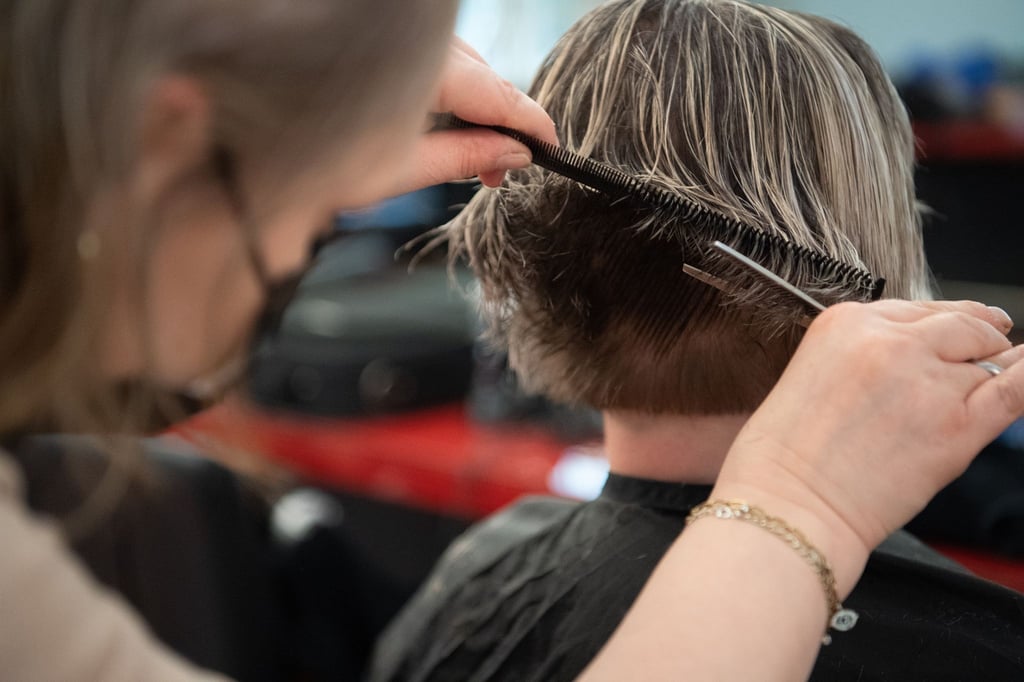 Eine Friseurin schneidet einer Kundin die Haare in einem Friseursalon.